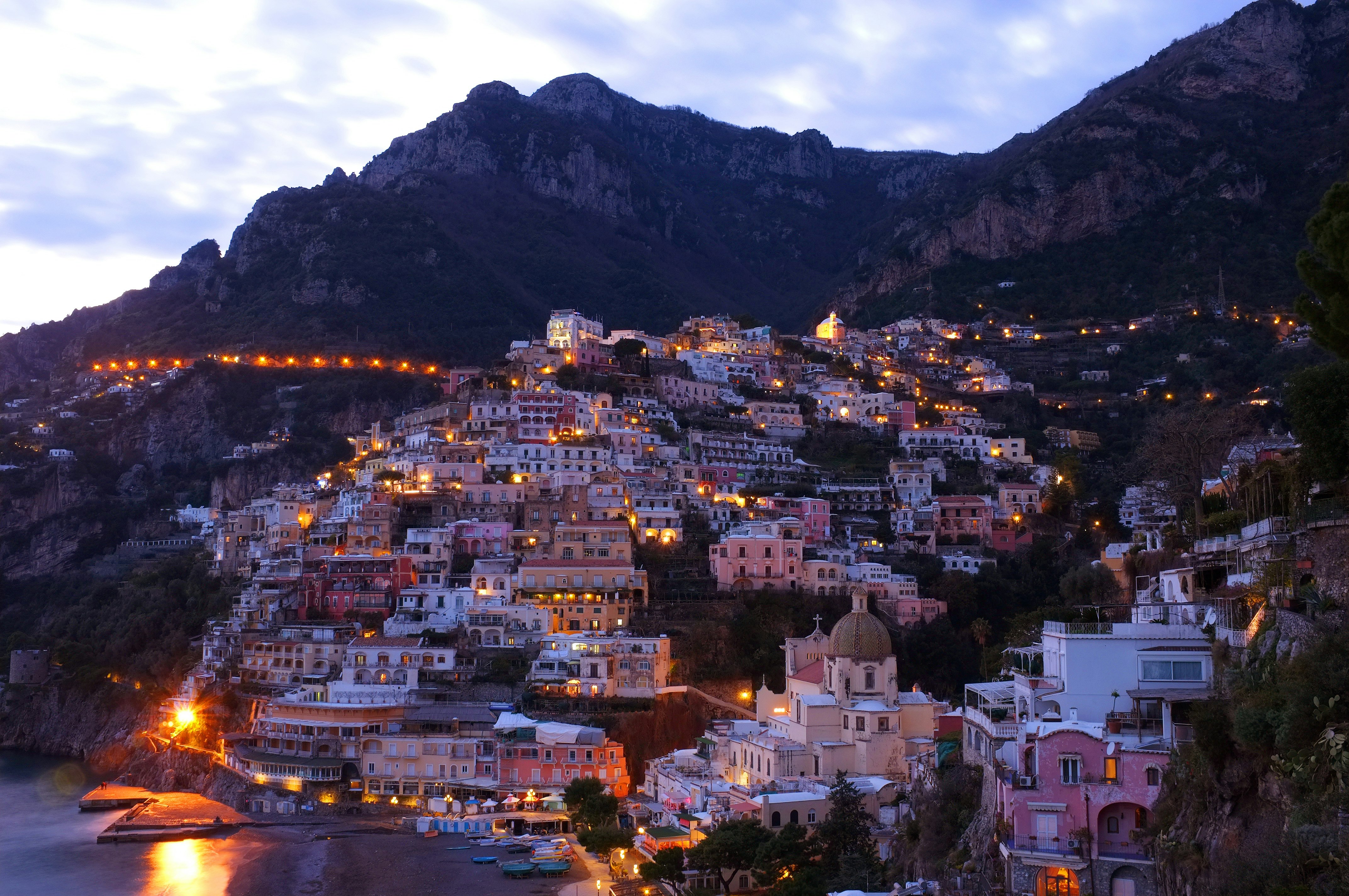 houses beside sea with mountain background